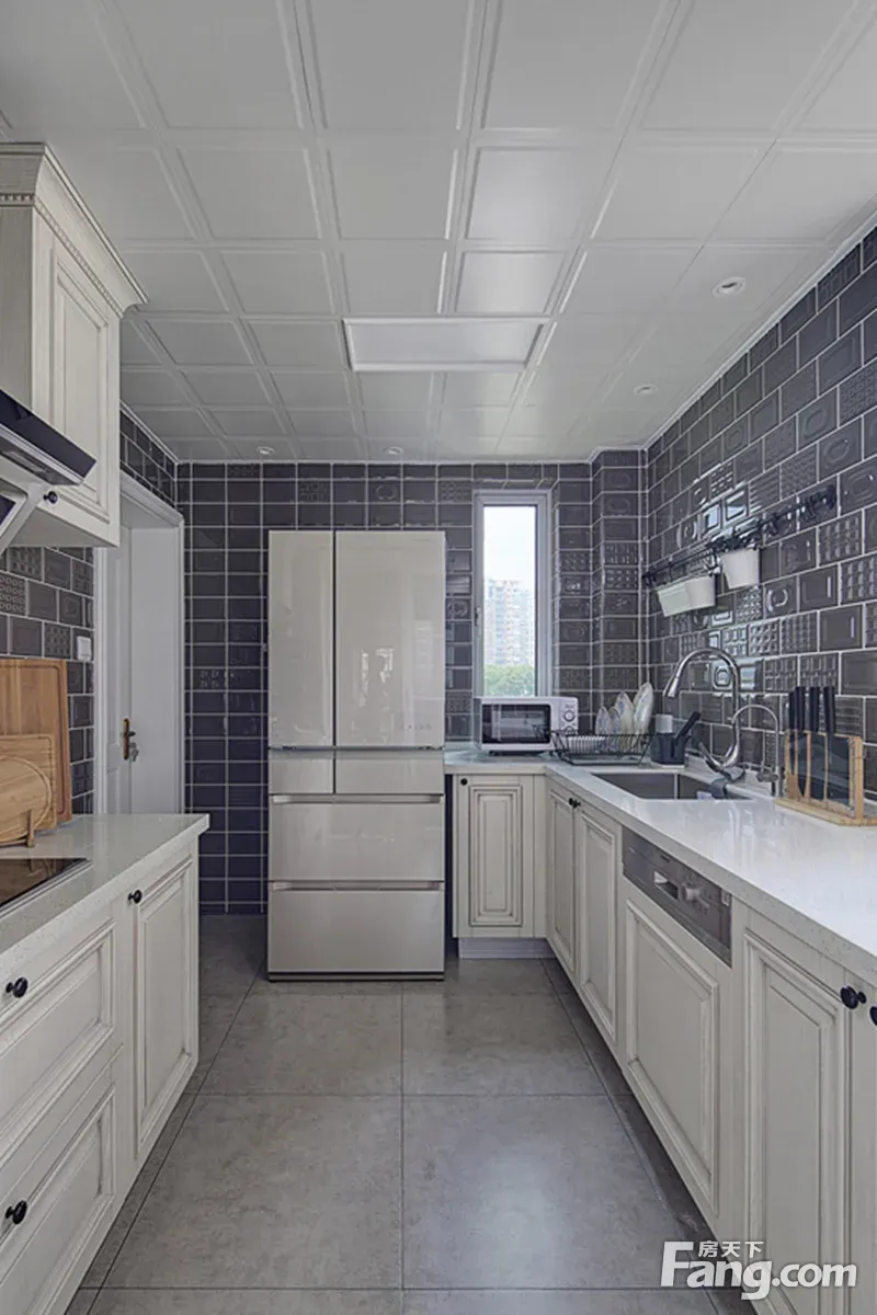 厨房用了大胆的颜色:紫灰色的墙砖,配上显纹白色橱柜,让整个空间变得